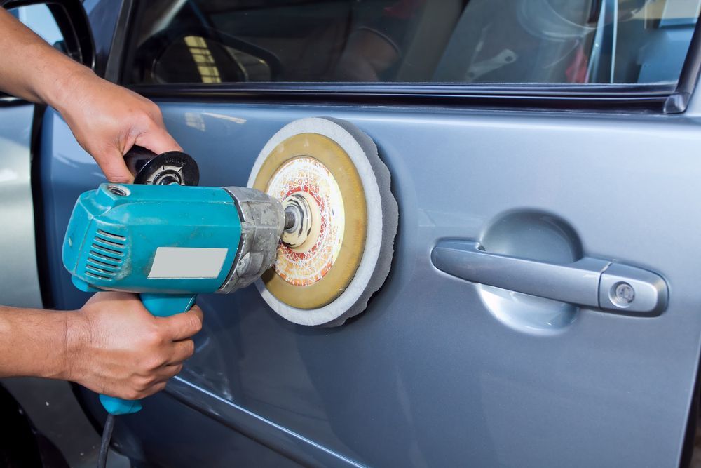 Person Polishing a Car Door With a Buffer, Next to the Door Handle — FNQ Paintless Dent Repair in Edmonton, QLD