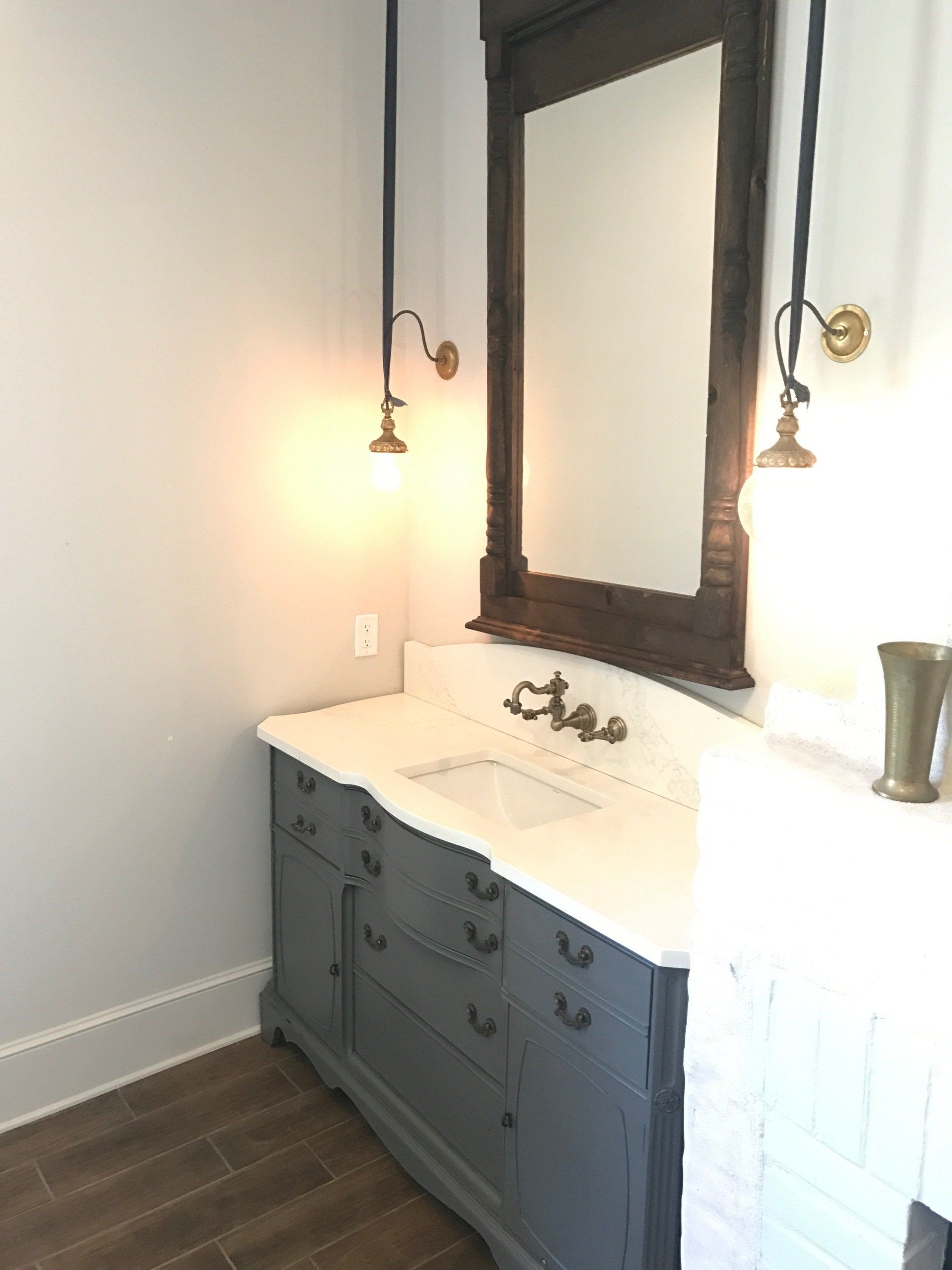 A bathroom with a sink , mirror and lamps | general contractor services