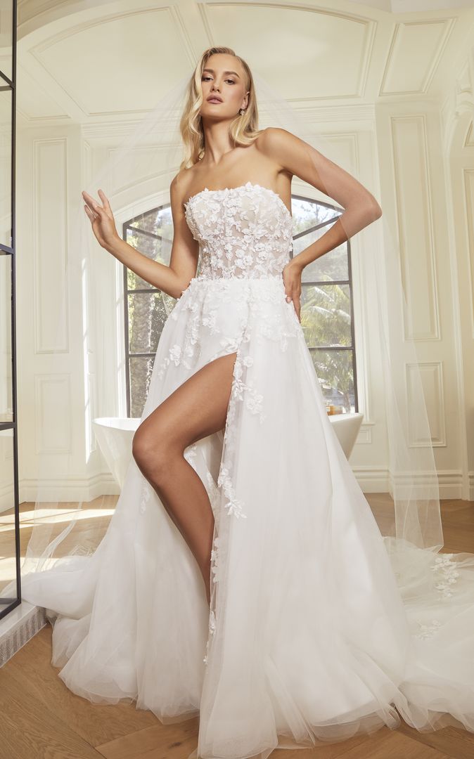 A woman is wearing a white wedding dress with a high slit.