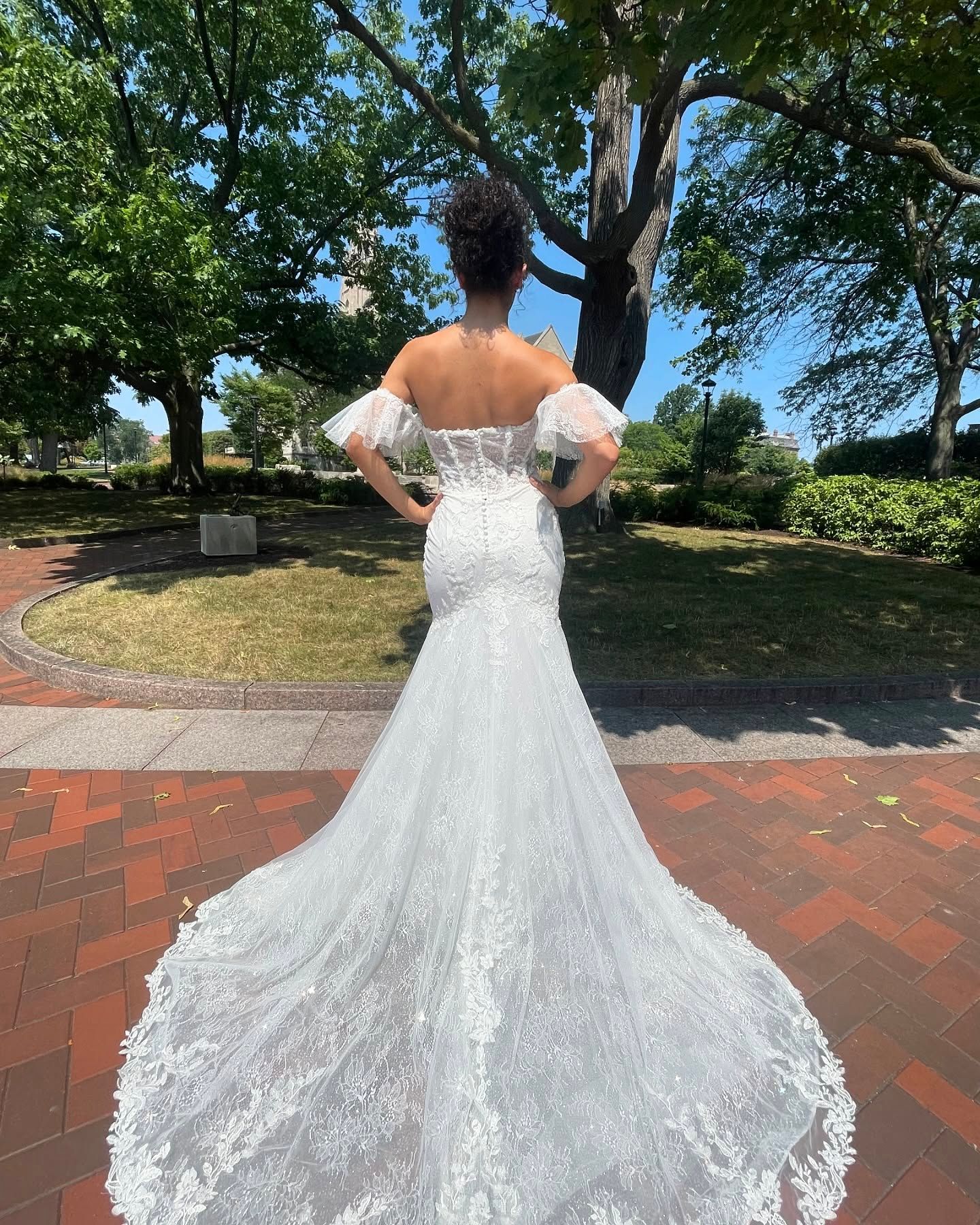 The back of a woman in a wedding dress is shown.