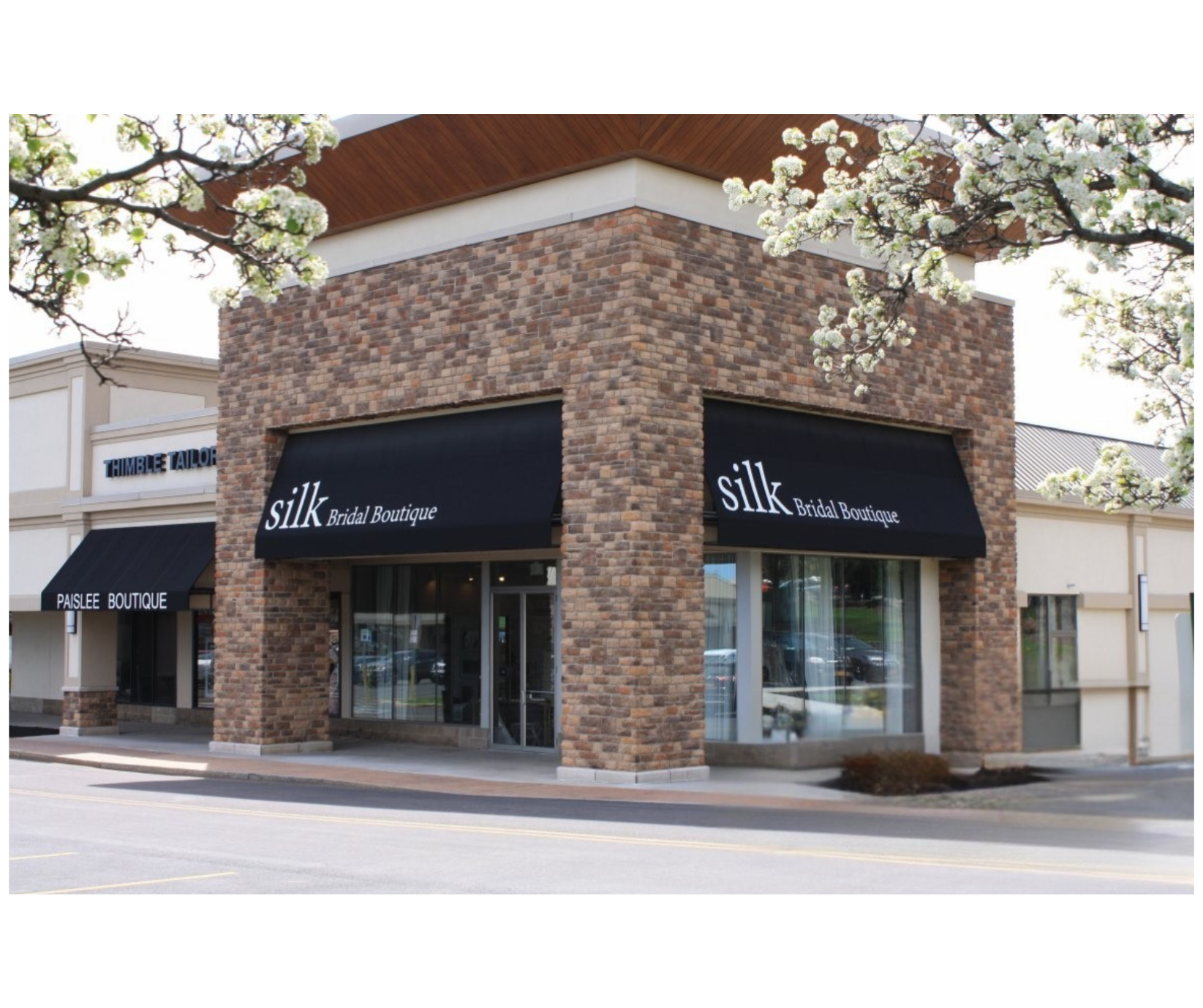 A store front with a black awning that says silk