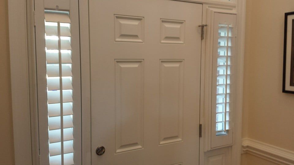 A white door with shutters on it in a room.