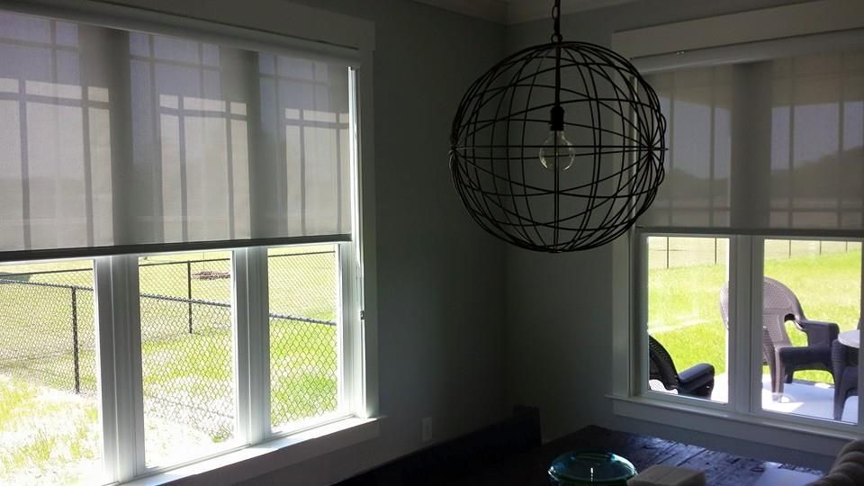 A living room with a lot of windows and a chandelier hanging from the ceiling.