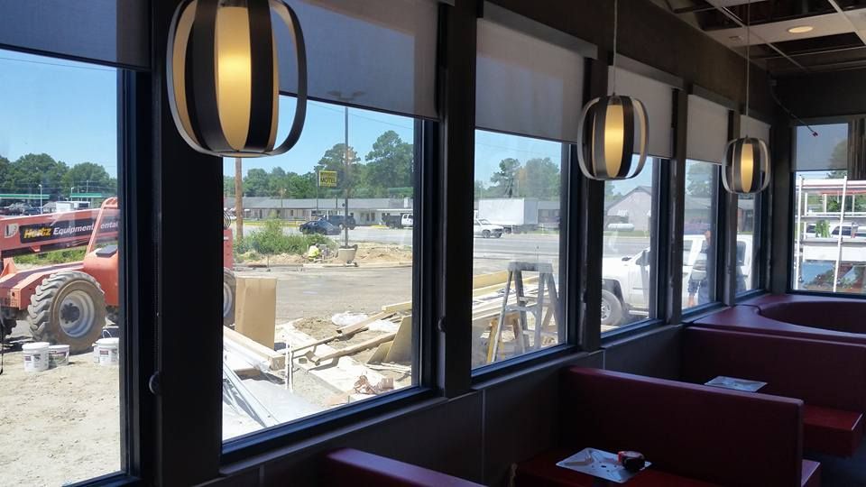 A restaurant with a lot of windows and a tractor in the background.