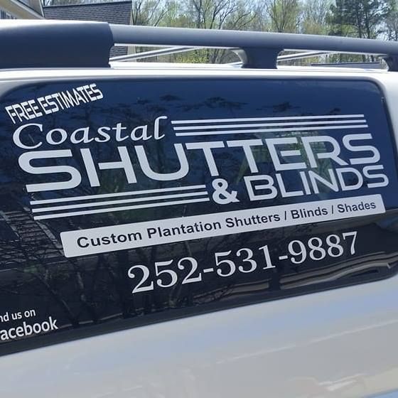 A van with a coastal shutters and blinds logo on the back window