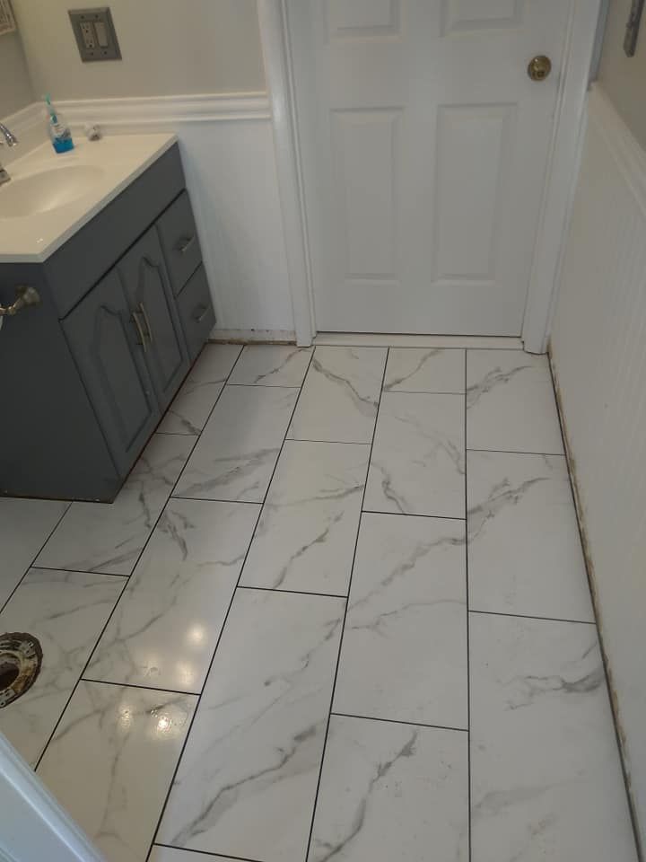 A bathroom with white tile floors and a sink