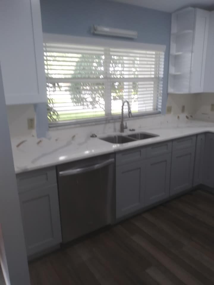A kitchen with two sinks and a window with blinds