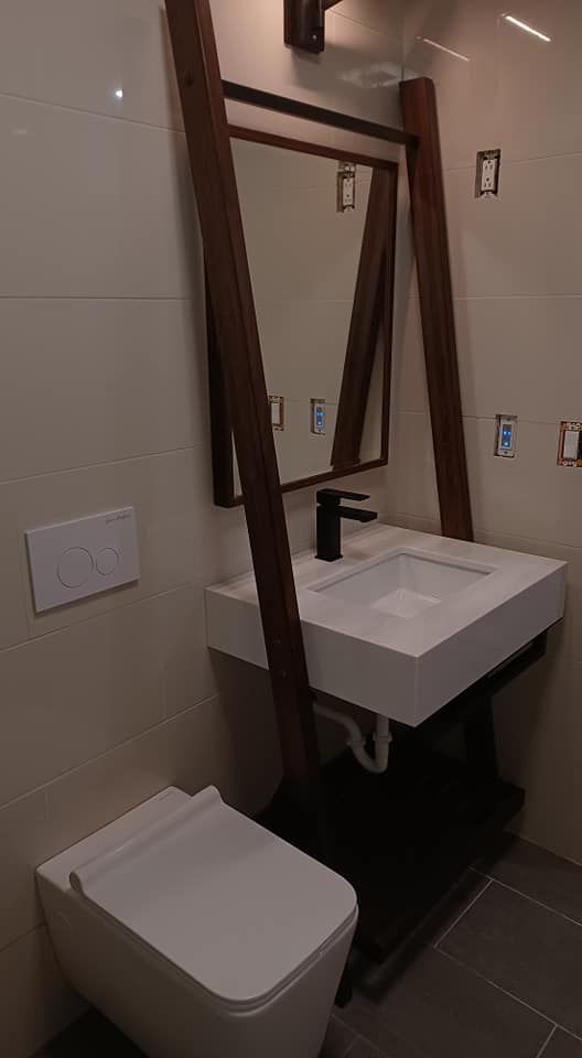 A bathroom with a toilet , sink and mirror.