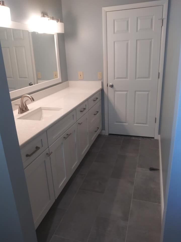 A bathroom with two sinks , a mirror and a door.