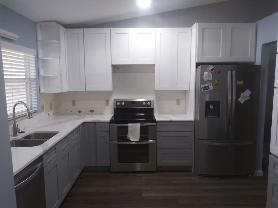 A kitchen with white cabinets and stainless steel appliances