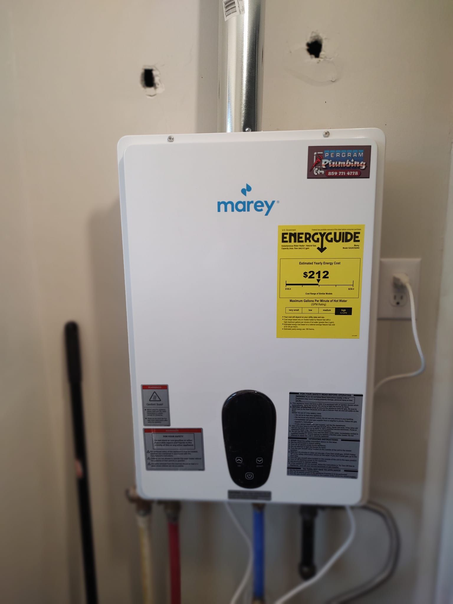 White Marey tankless water heater mounted on a wall with pipes and vent.