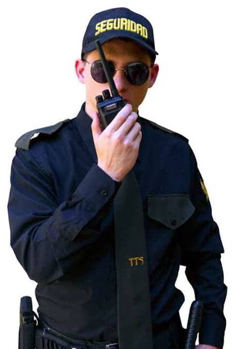 Un hombre que lleva gafas de sol y un casco de seguridad sostiene un walkie talkie.