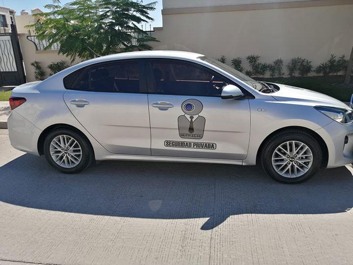 Un coche plateado está aparcado al costado de la carretera.