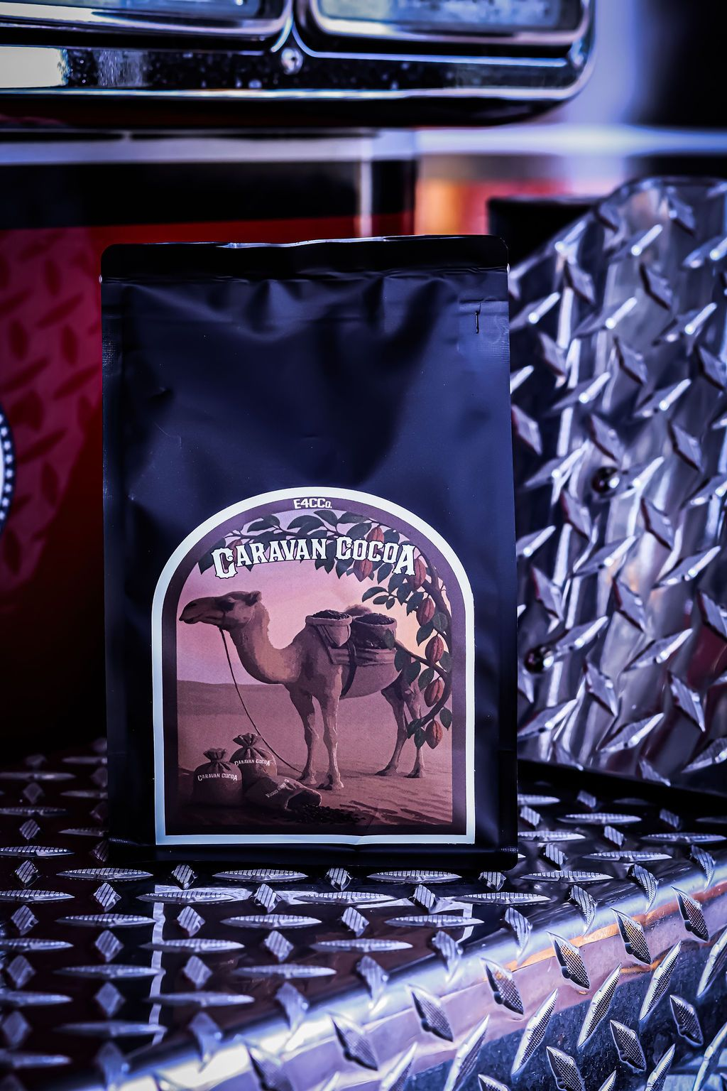Bag of Caravan Baba coffee, featuring a camel graphic on a desert landscape, black background.