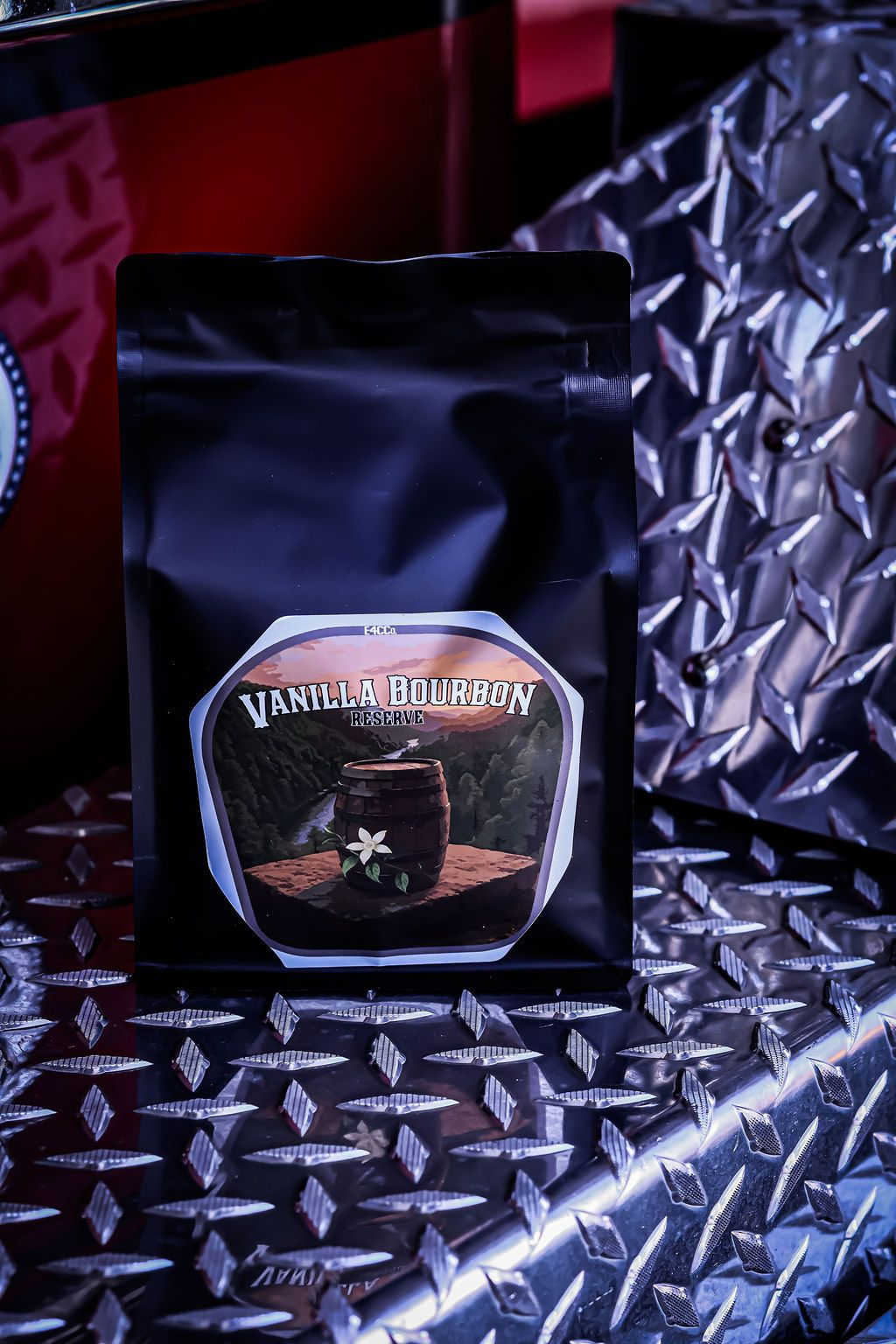 Black coffee bag with label, against a diamond plate surface.