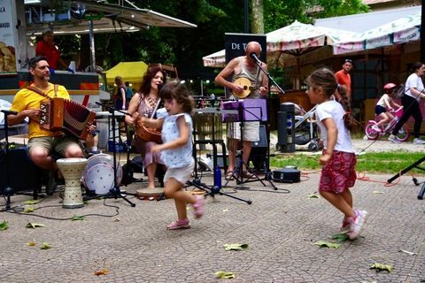 Fuori c'è una banda che suona musica, due ragazze ballano lì vicino.