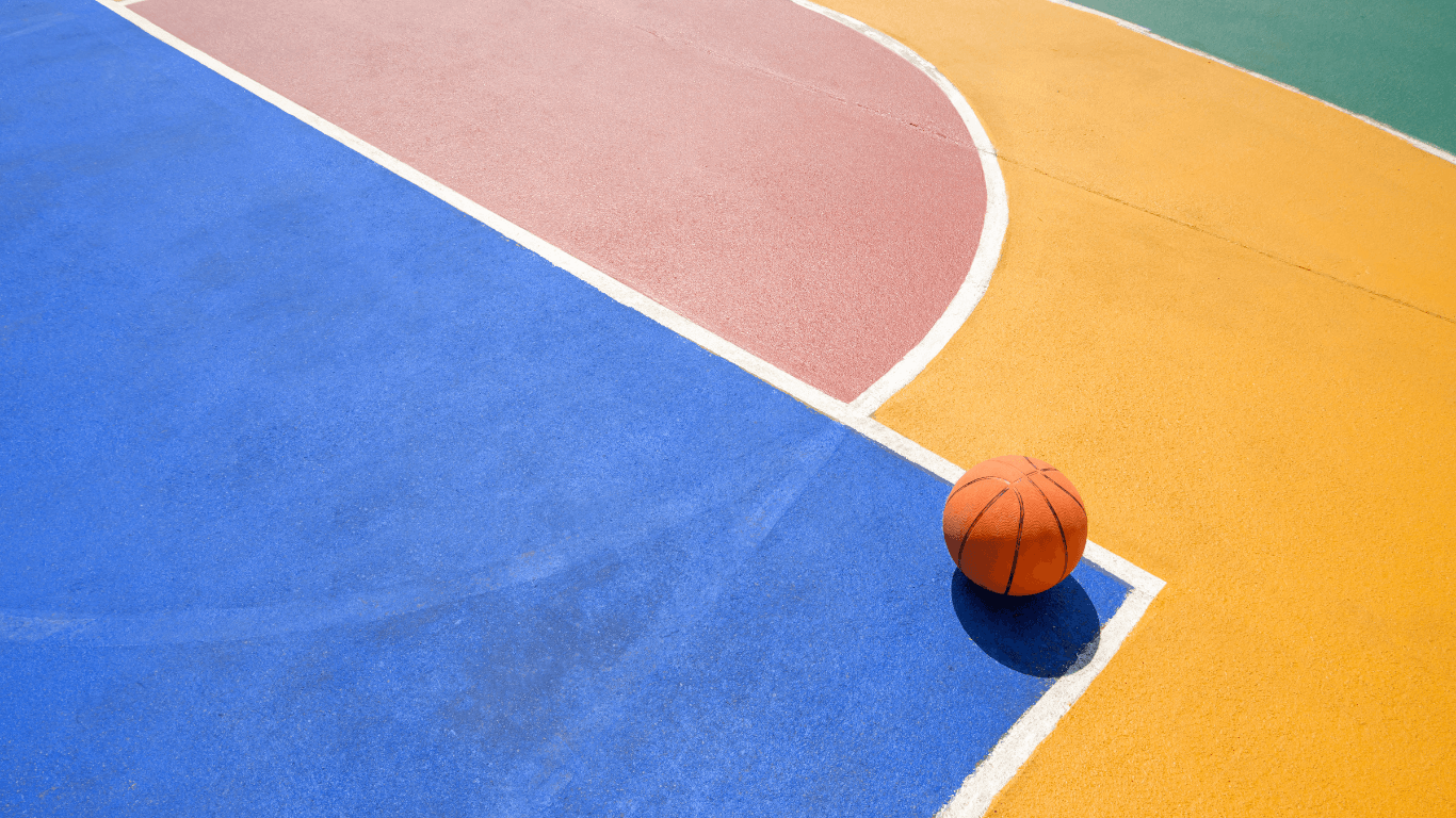 Bright multi-colored sport court surface with a basketball resting near painted lines during a court installation service in Chandler, AZ
