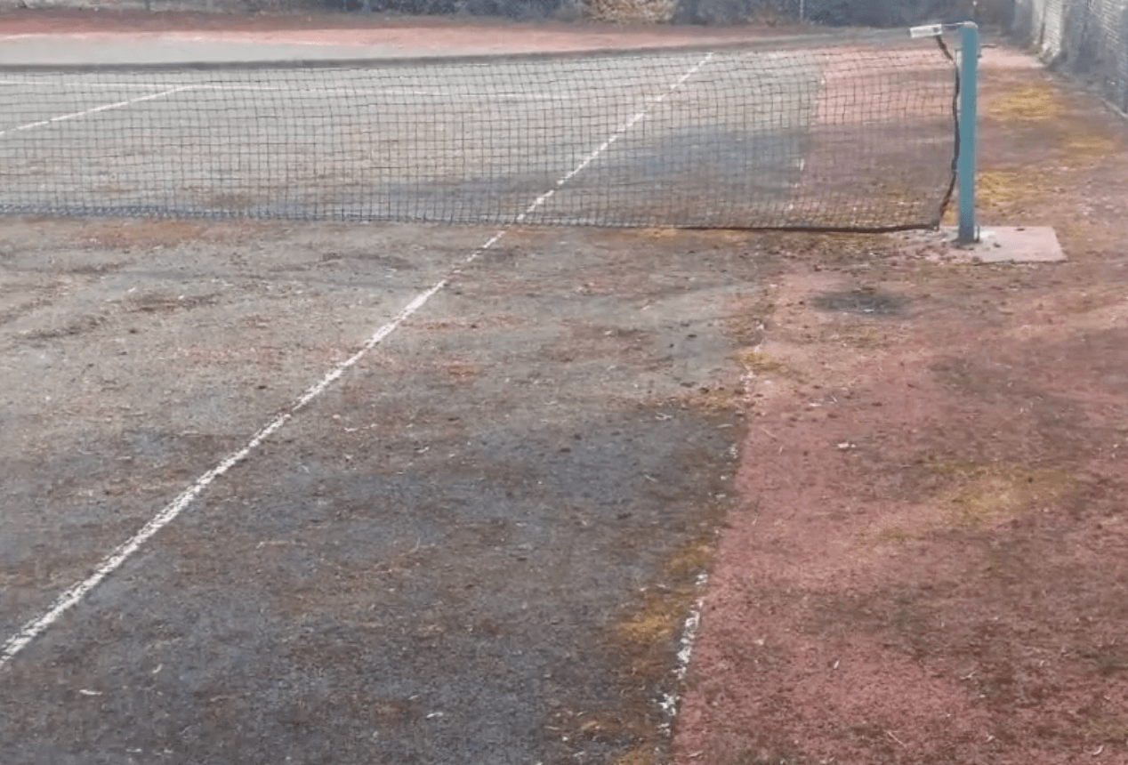 Old tennis court with faded lines and worn surface prior to upgrade during a court installation service in Chandler, AZ