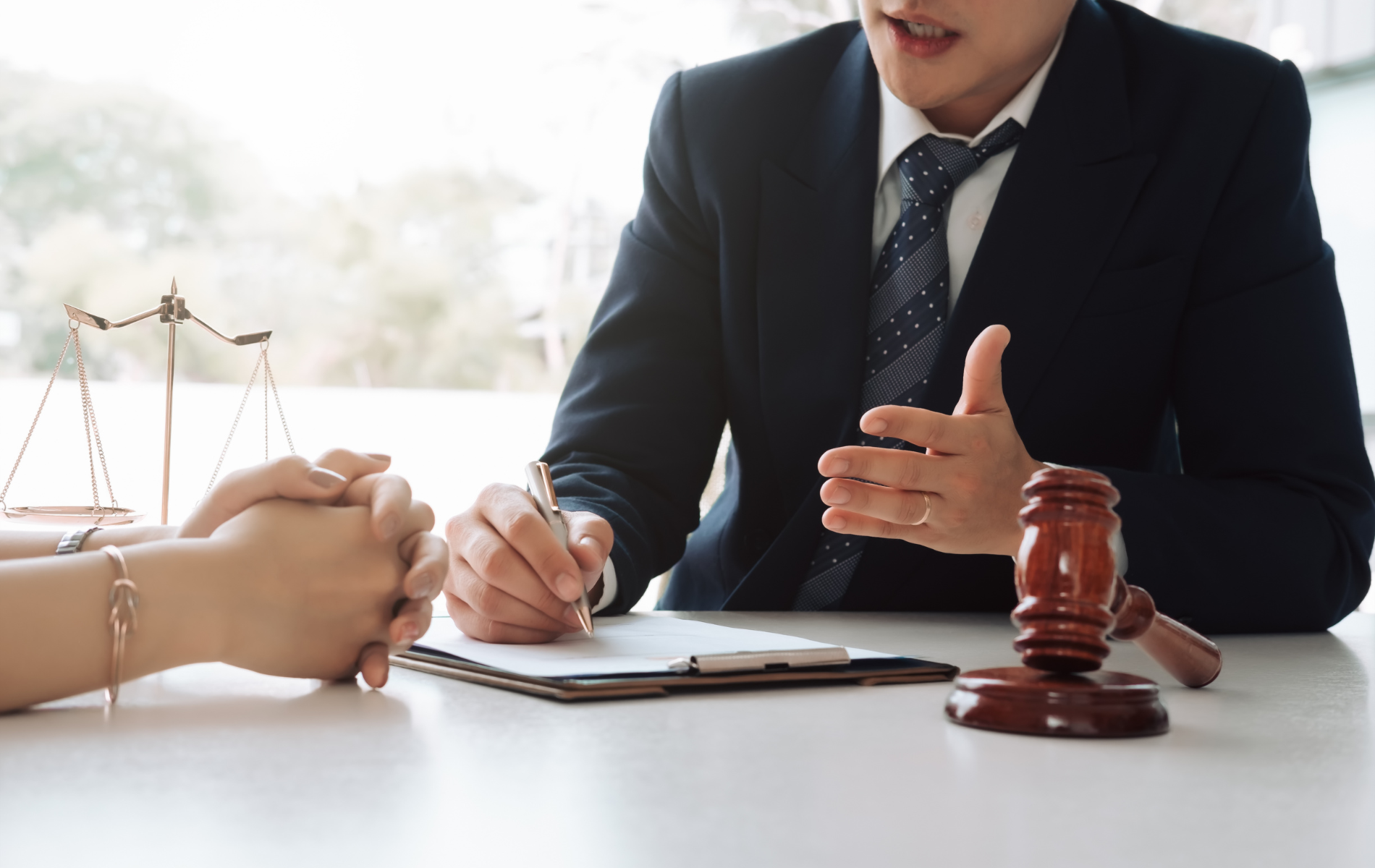 A man in a suit and tie is sitting at a table talking to a woman.