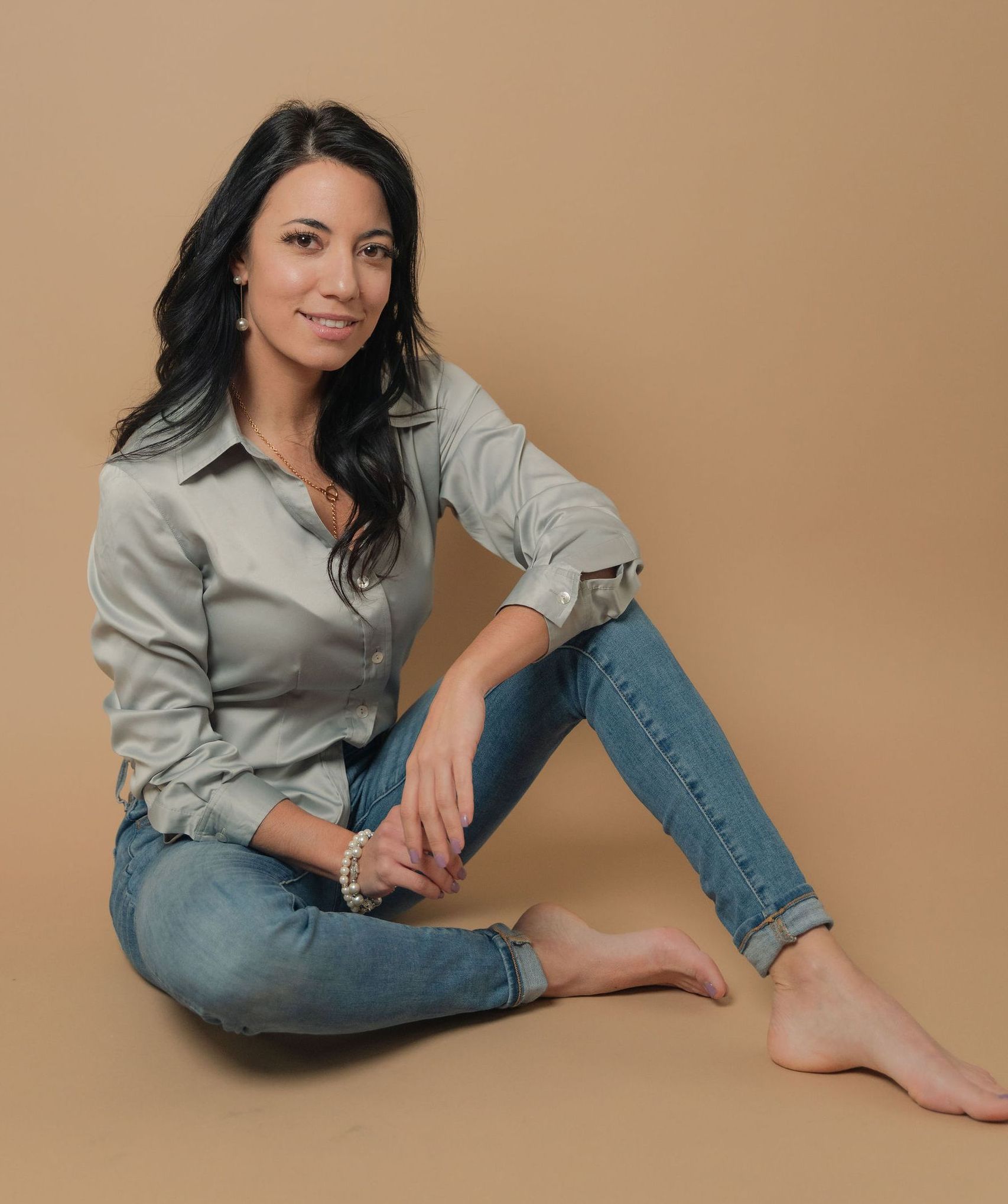 A woman is sitting on the floor with her legs crossed