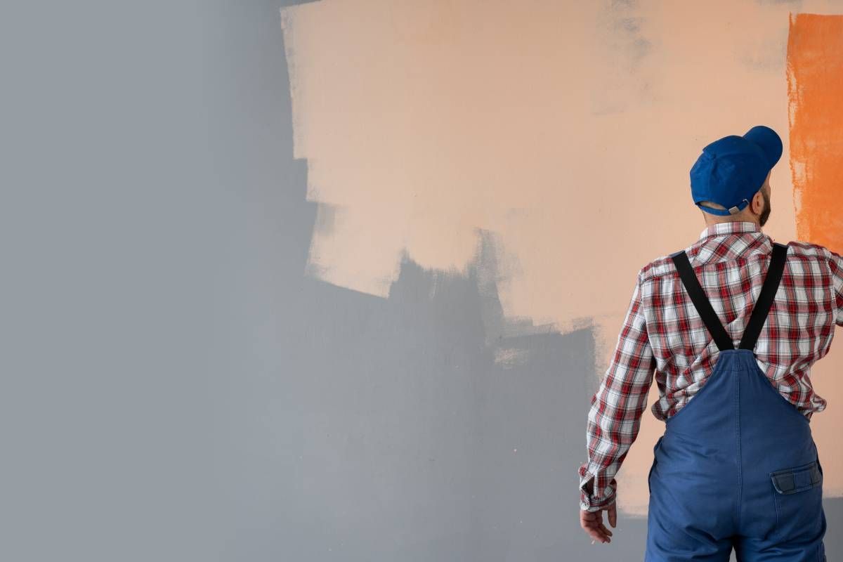 A professional painter coating a wall in orange paint at All About Painting near Johnson City, Tennessee (TN)