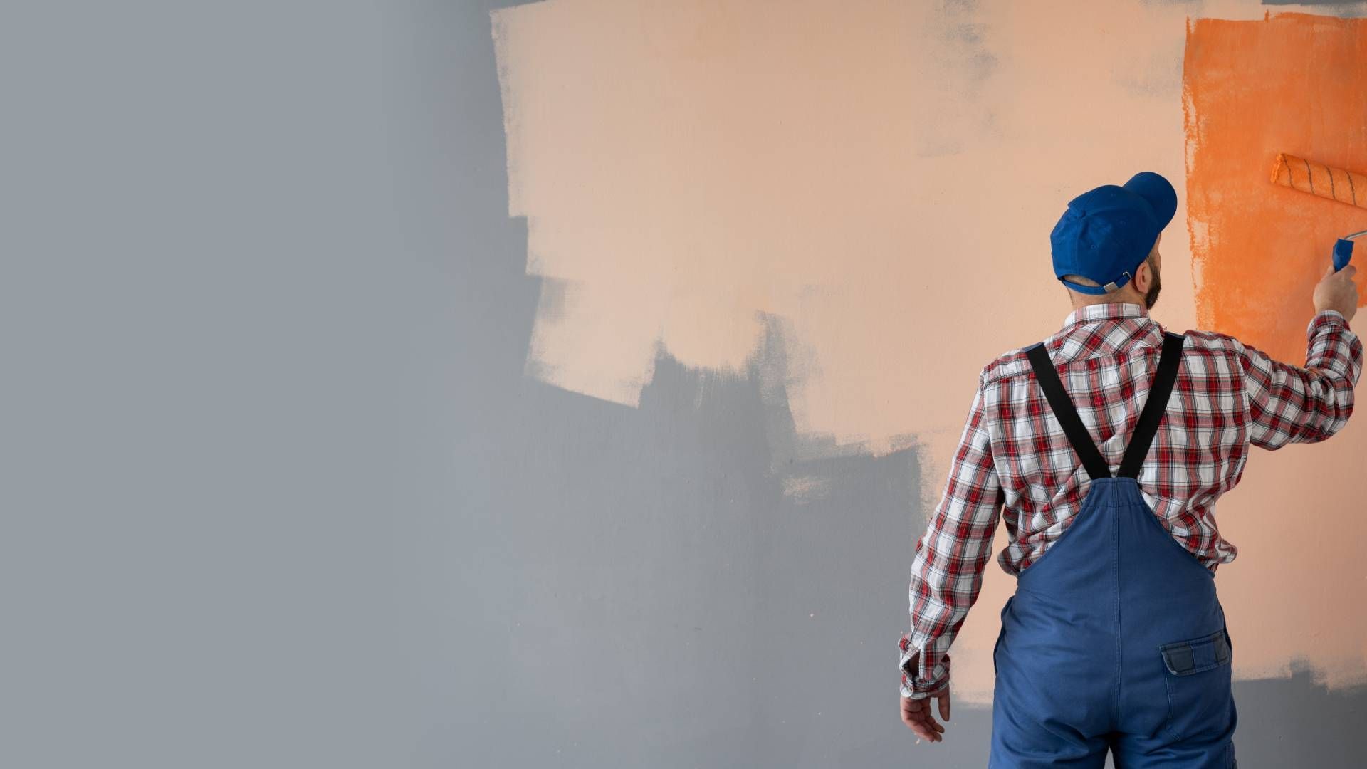 A professional painter coating a wall in orange paint at All About Painting near Johnson City, Tenne