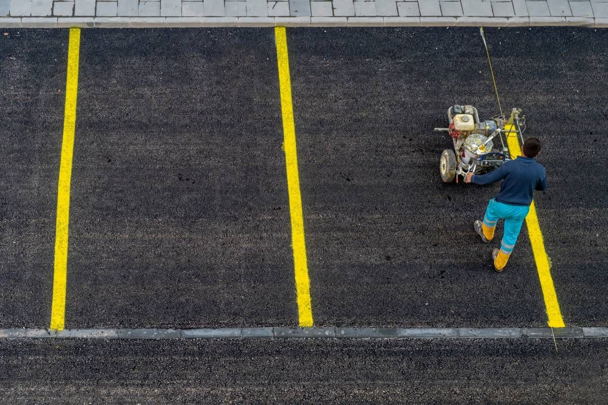 Worker painting a commercial parking lot near Johnson City, TN