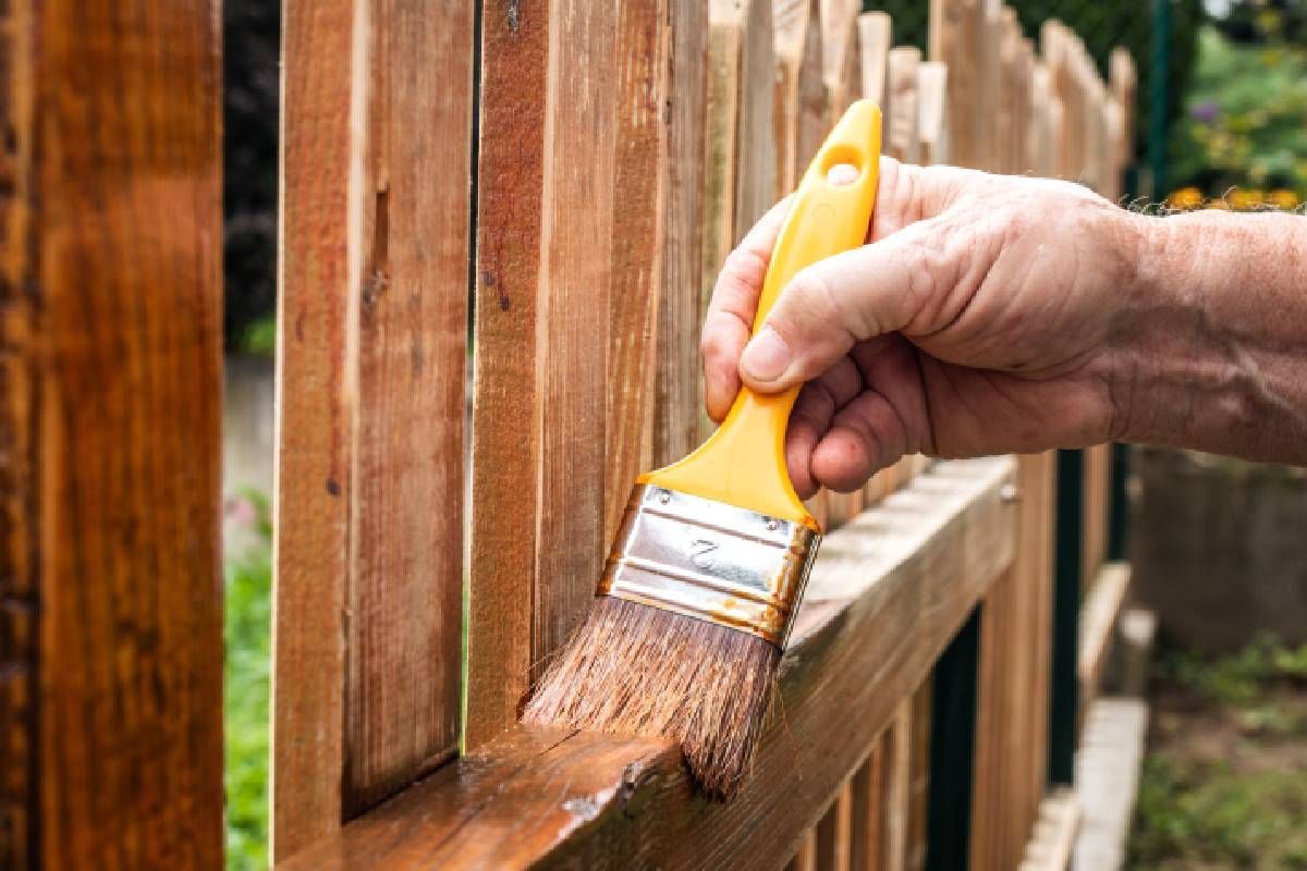 Some applying stain to a wood fence near Johnson City, Tennessee (TN)