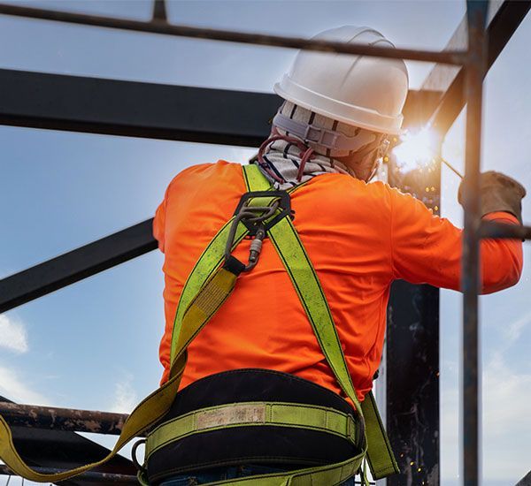 A man wearing a hard hat and safety harness