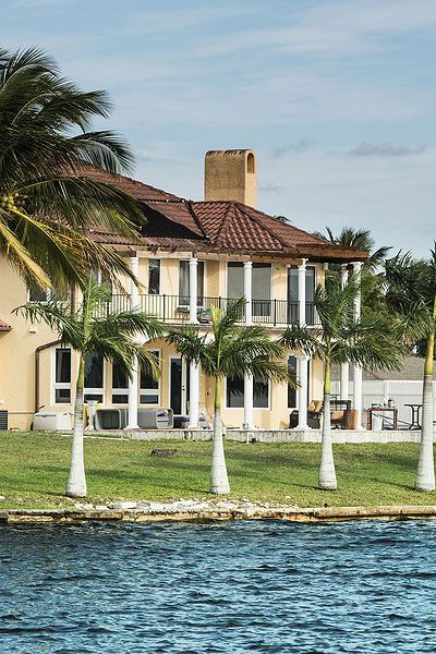 A waterfront home in Cape Coral, Florida with a tile roof and palm trees