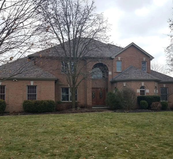 A red brick home with a new roof installed by Allstate Exteriors