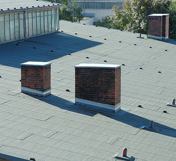 Commercial flat roof with chimneys and other structures