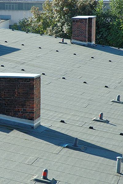 Commercial flat roof with chimneys and other structures