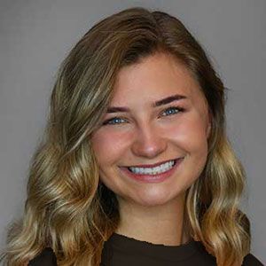 a young woman with long blonde hair is smiling for the camera