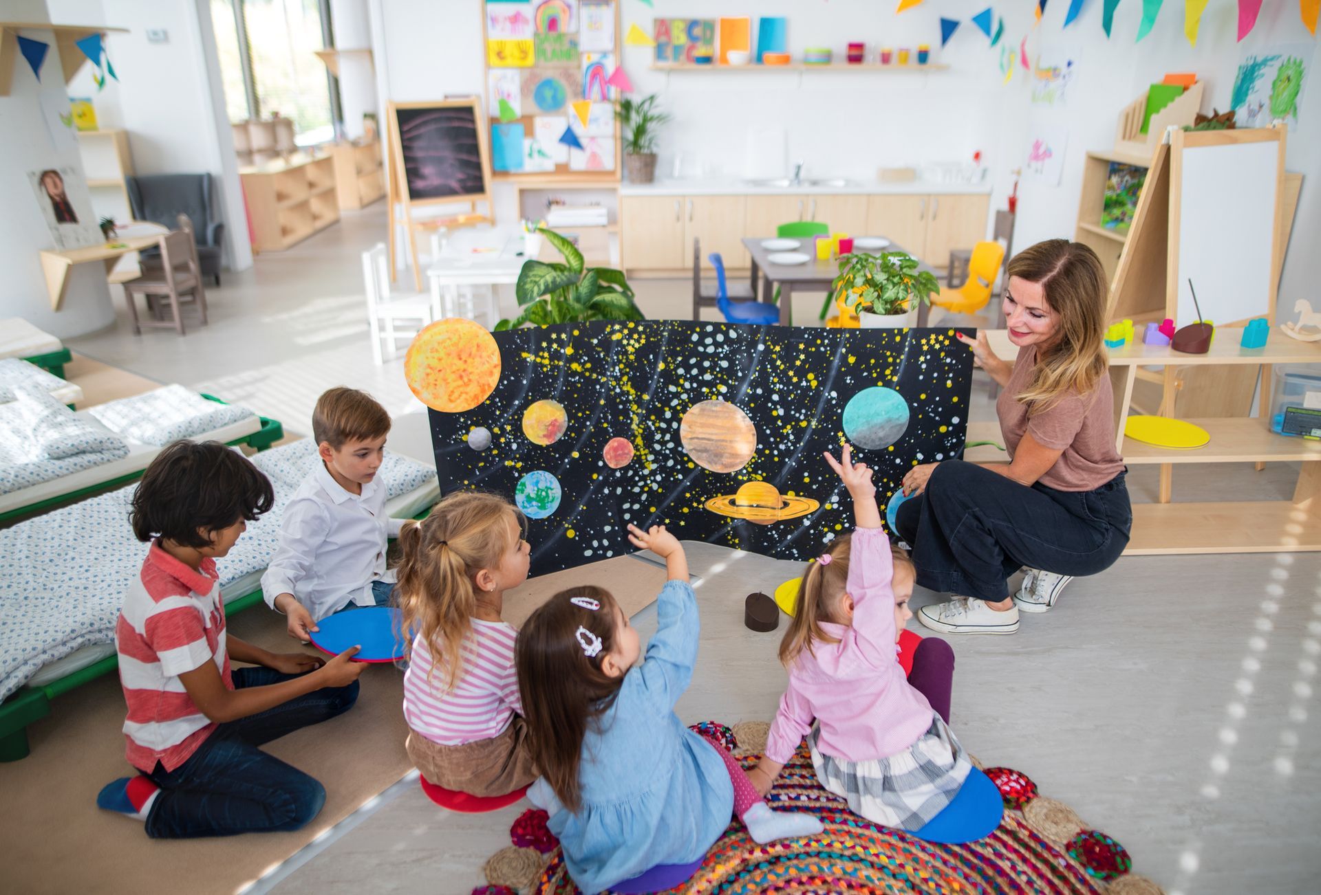 A teacher is teaching a group of children about the solar system.