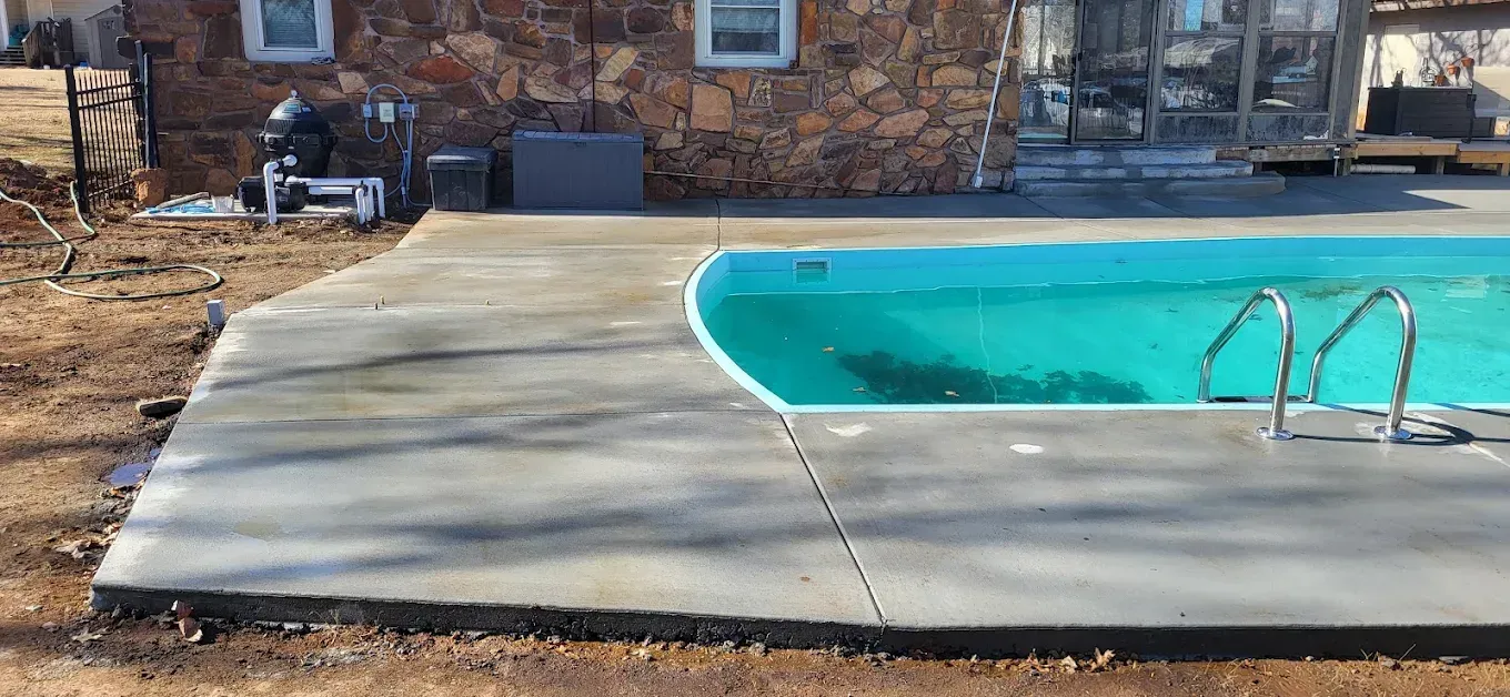 Patio with wicker furniture under a wooden ceiling, gray walls, and glass windows overlooking a backyard.