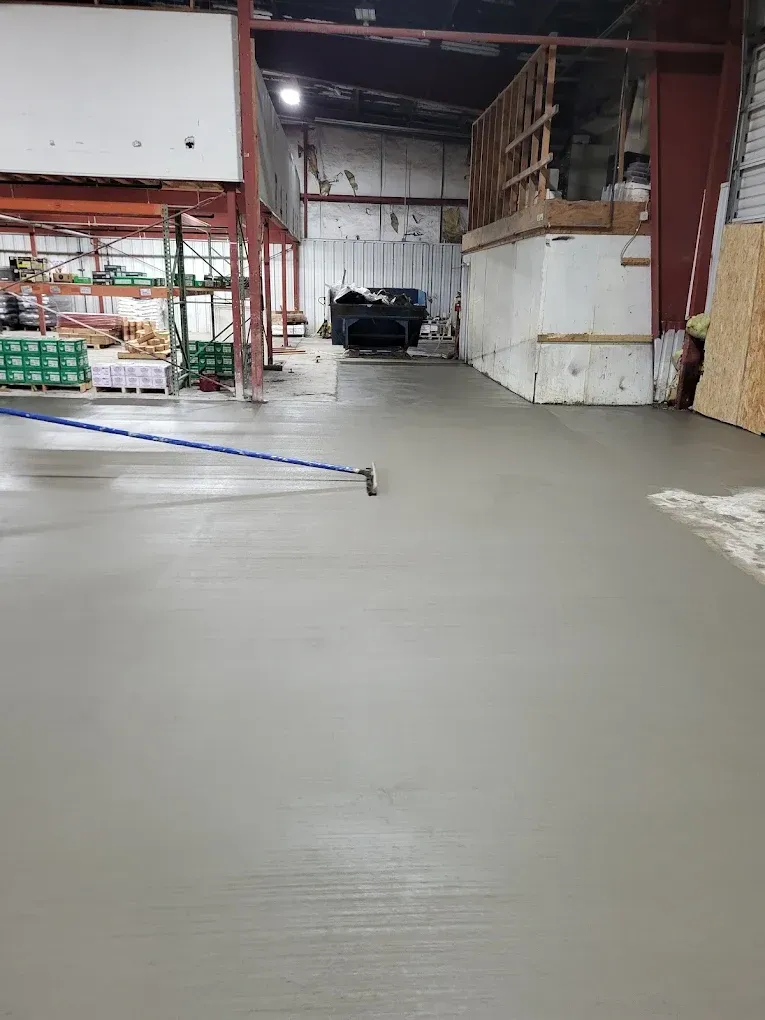 Empty, bright white garage with an open garage door and a window.
