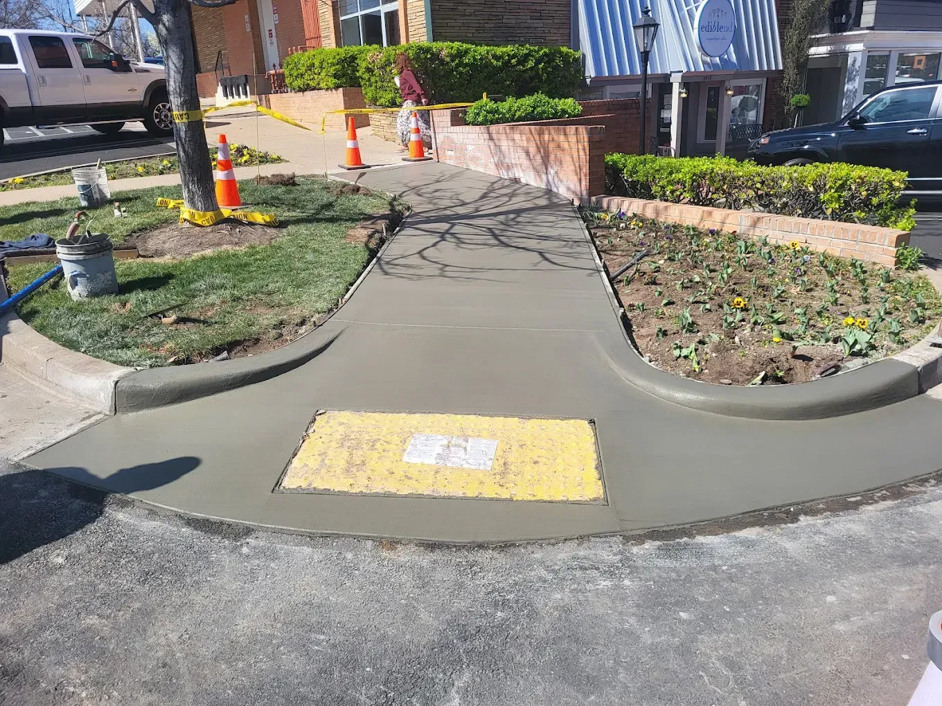 Hand smoothing wet concrete with a trowel, creating a flat surface.