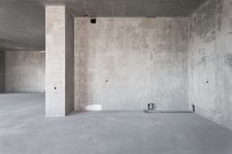 Empty concrete room with pillars and unfinished walls.