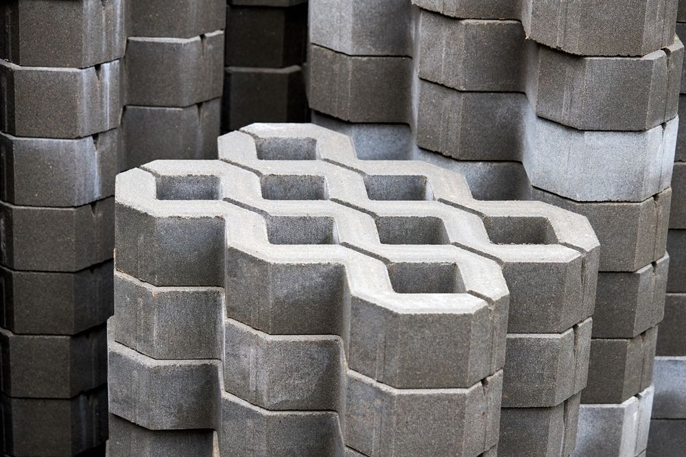 Stacked gray interlocking concrete pavers.