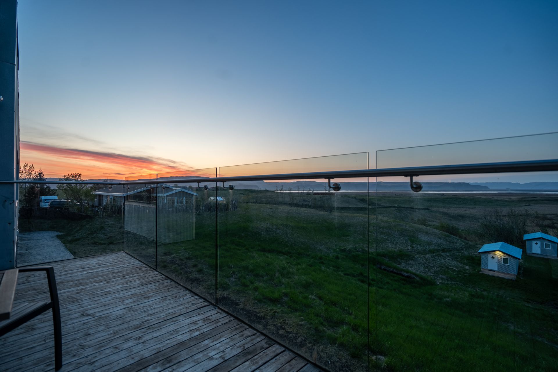A balcony with a view of the ocean at sunset.