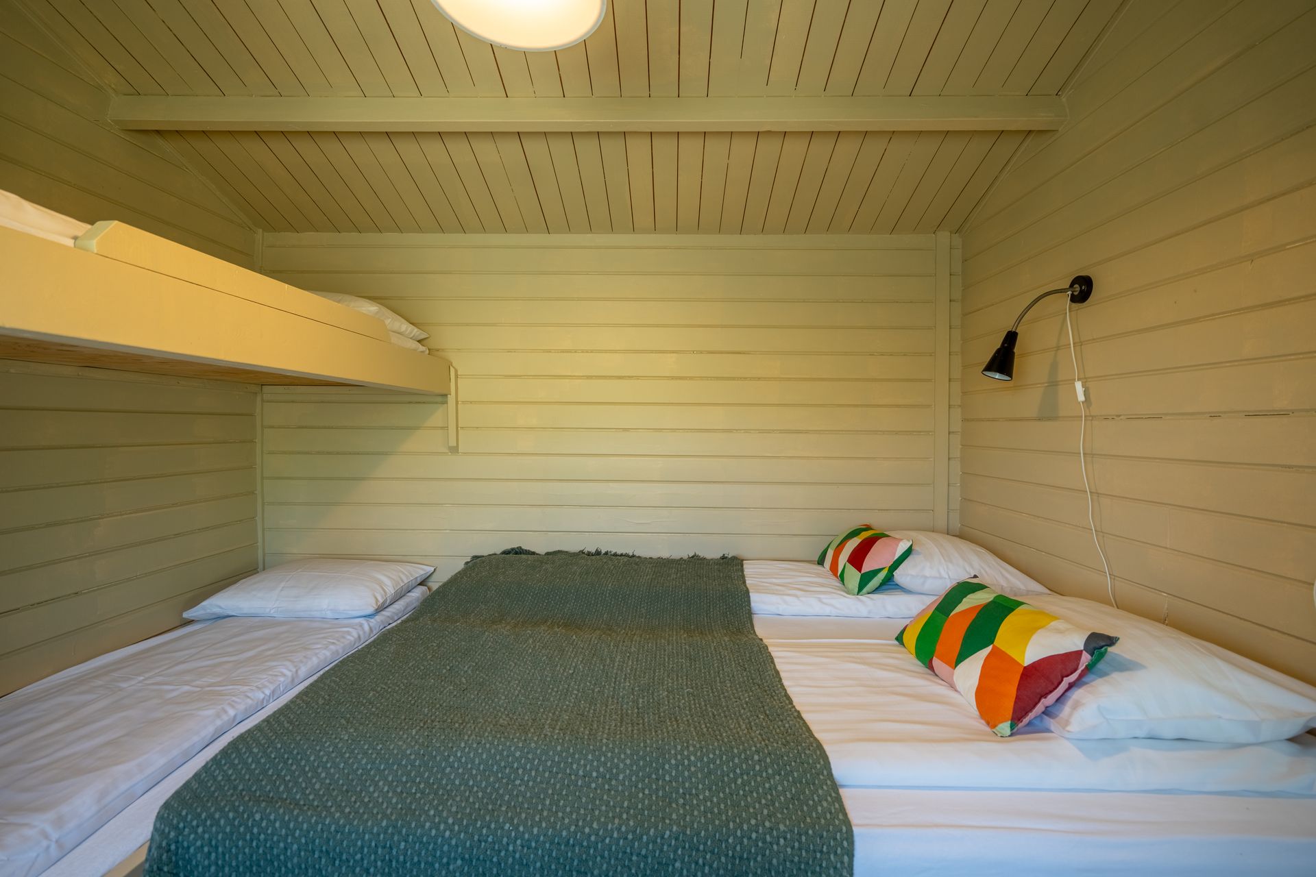 A bedroom with two beds and a bunk bed.