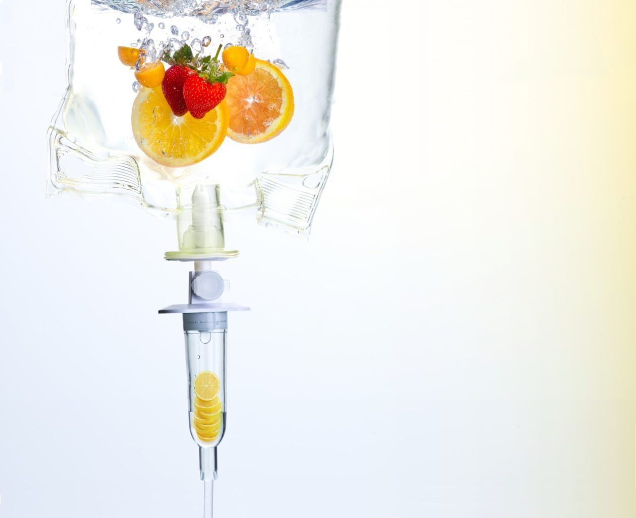 IV bag with fruit slices, dripping liquid, against a gradient background.