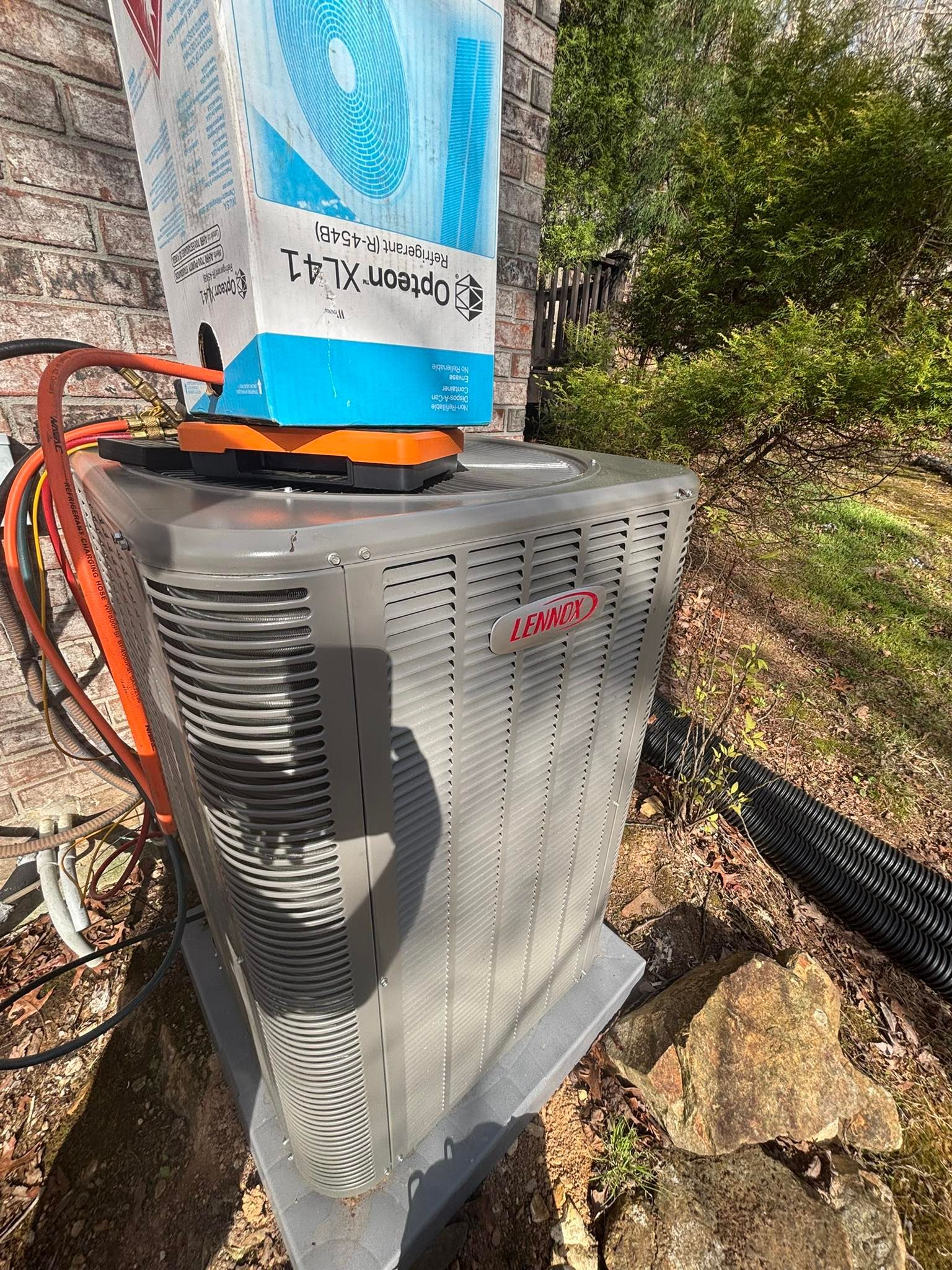 A large air conditioner is sitting on top of a pile of rocks.