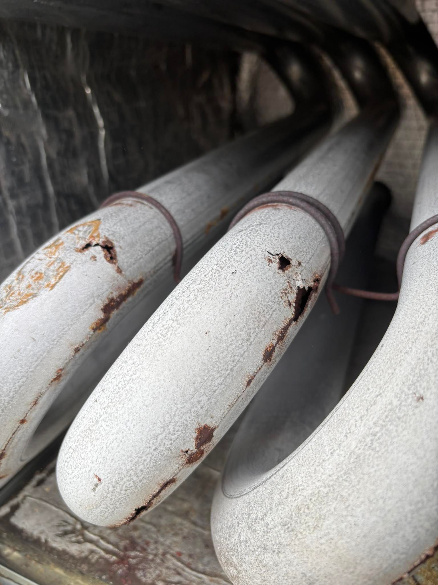 A close up of a bunch of white pipes with rust on them.