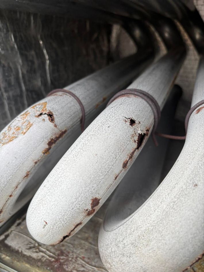 A close up of a bunch of white pipes with rust on them.