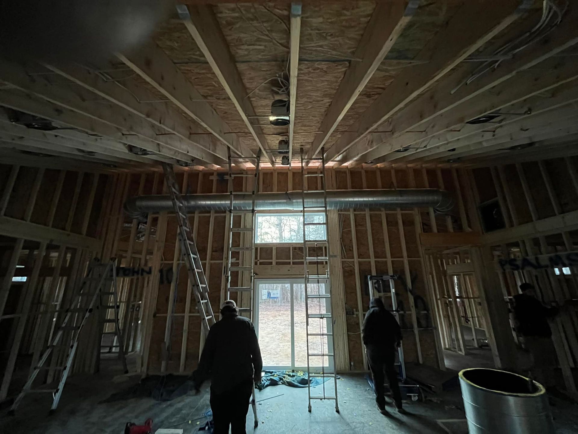 A man is standing in the middle of a building under construction.