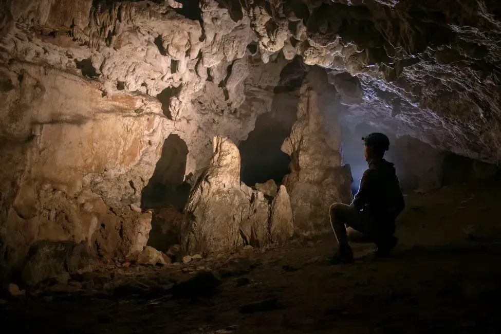 a person staring at rock formation in klang cave