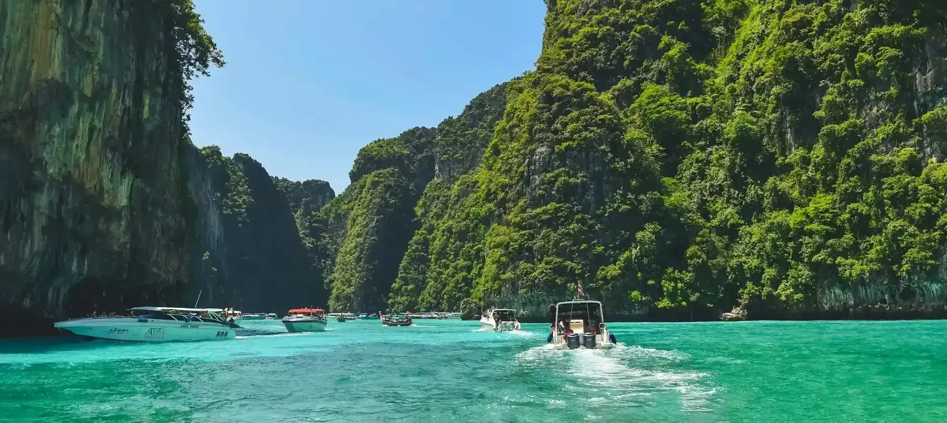 multiple boats surrounded by islands in krabi