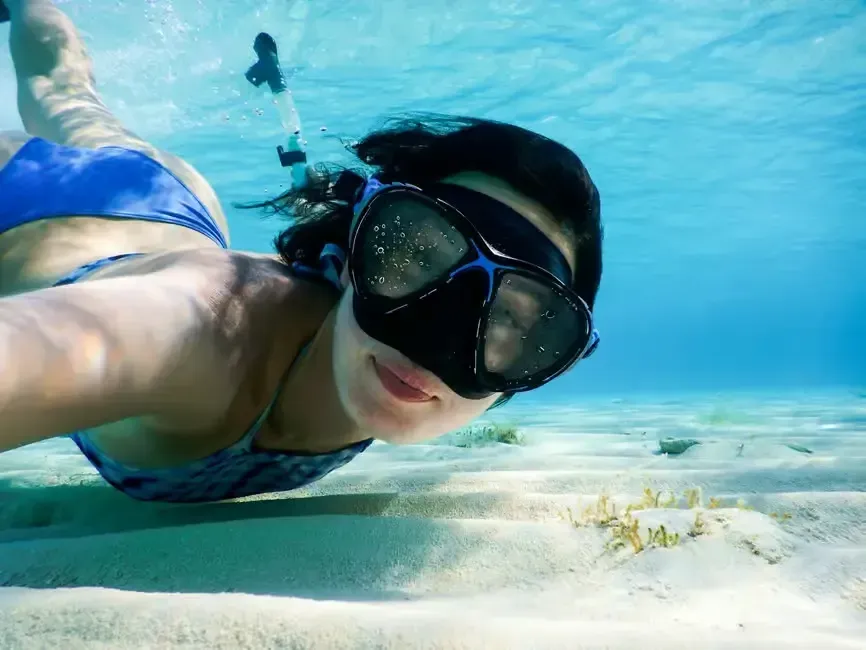 a woman taking a selfie while snorkeling